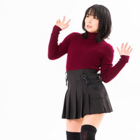 あまりの恐怖に尻込みする赤いセーターの女性の写真