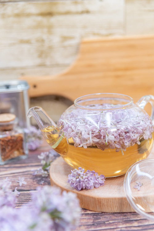 ライラック入りのハーブティーポットと木製トレー