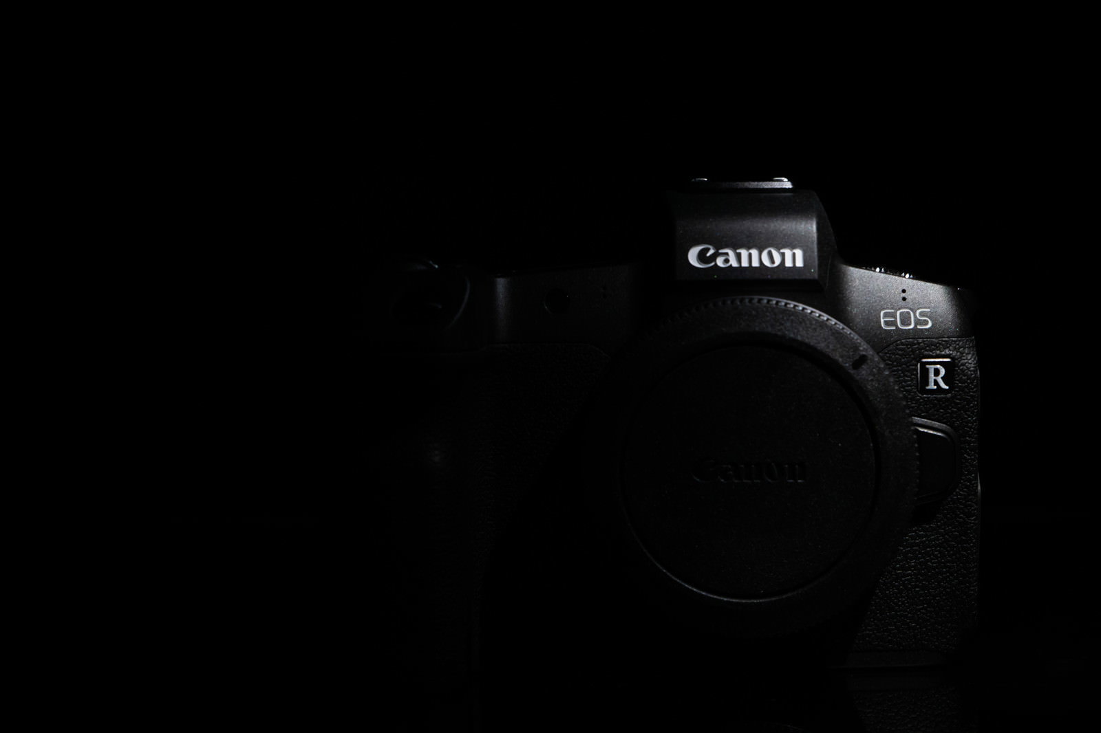 黒い背景に置かれたCanon EOS Rフルサイズミラーレスカメラ