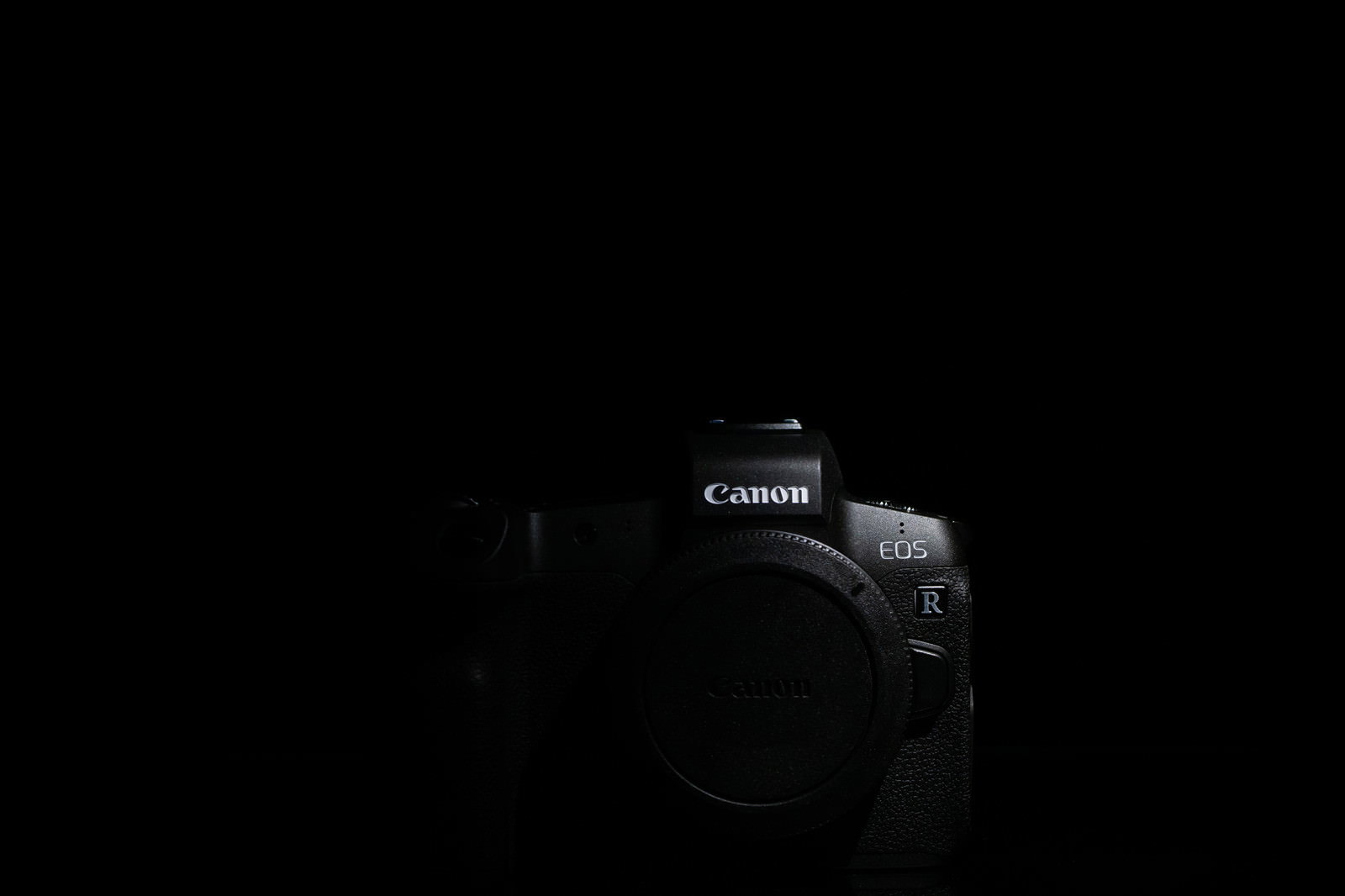 暗い背景に置かれたCANON EOS Rのミラーレス一眼レフカメラボディ