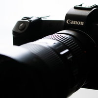 黒いボディにレンズを装着したCanonミラーレスカメラの写真