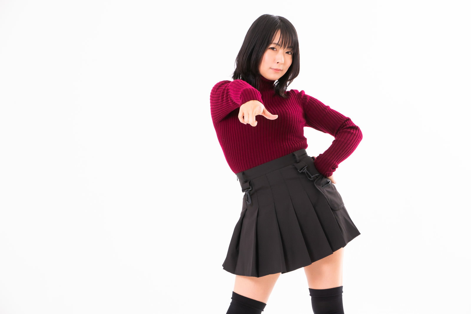 片手を腰に当てて指令するようなポーズをとる赤い服の女性［モデル：にゃるる］