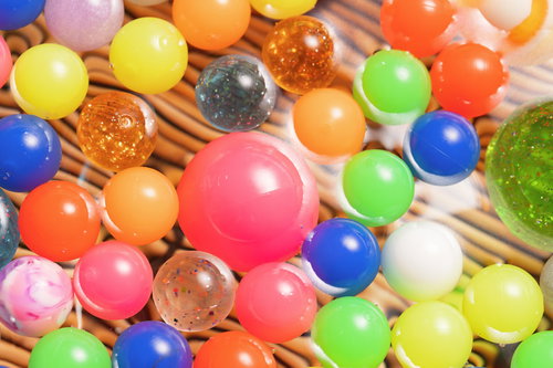 竹ざるの上に浮かぶカラフルなスーパーボール