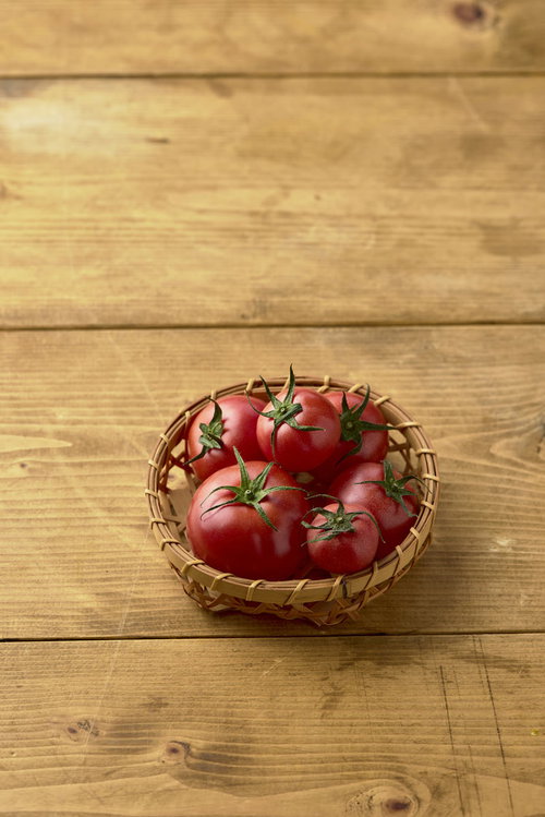 籠に入った蔕付きミニトマト、新鮮な赤いトマトの野菜