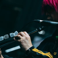 マイクスタンドにギターピックを刺すギタリストの手元の写真