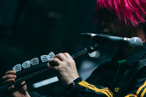 マイクスタンドにギターピックを刺すギタリストの手元