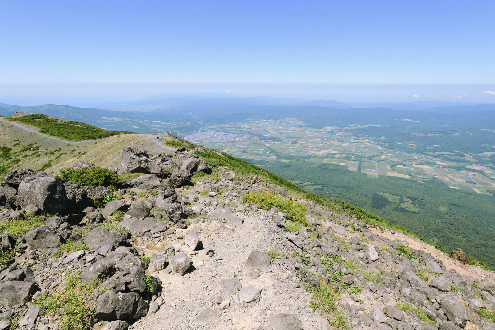 羊蹄山の山頂付近から京極方面の盆地と遠くの山々を見下ろす眺望