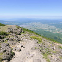 羊蹄山山頂から京極方面を眺める登山道と遠景の写真