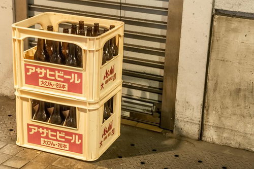 店先に積まれた黄色いケースの空き瓶ビール