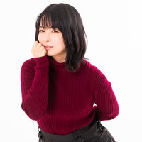 口元に手を添え静かに微笑む女性のポートレートの写真