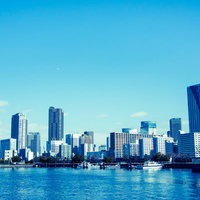 川沿いに立ち並ぶ都会のビル群と河川風景の写真