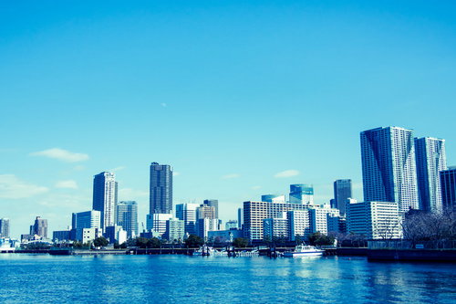 川沿いに立ち並ぶ都会のビル群と河川風景