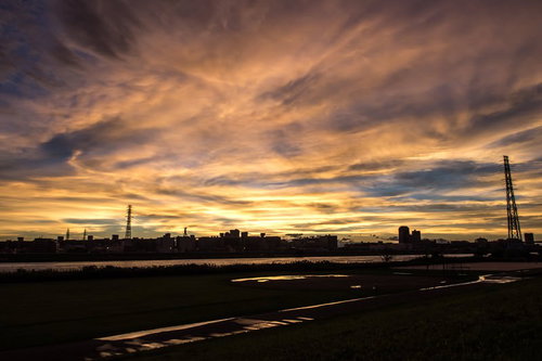 河川沿いの街並みと夕暮れ、通信塔のシルエット