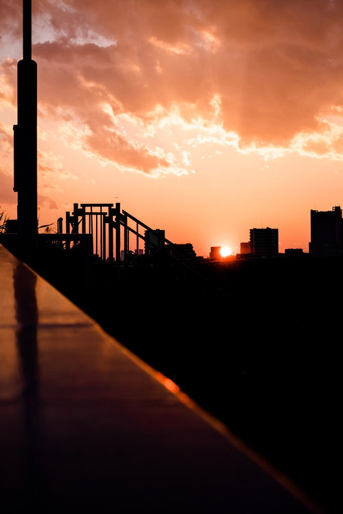橋と高層ビルのシルエット映える夕焼け空と都市夜景