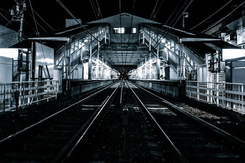 都内の駅のホームから見た線路の奥行きと架線