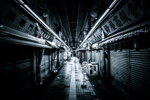 シャッターが閉まった夜間の商店街とアーケード