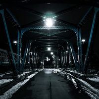 夜間に街灯に照らされた雪が残る鉄橋の夜景風景の写真