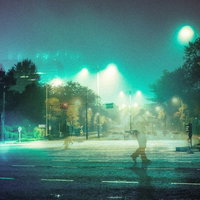 徘徊する人と深夜の街灯に照らされた夜の街（フォトモンタージュ）の写真