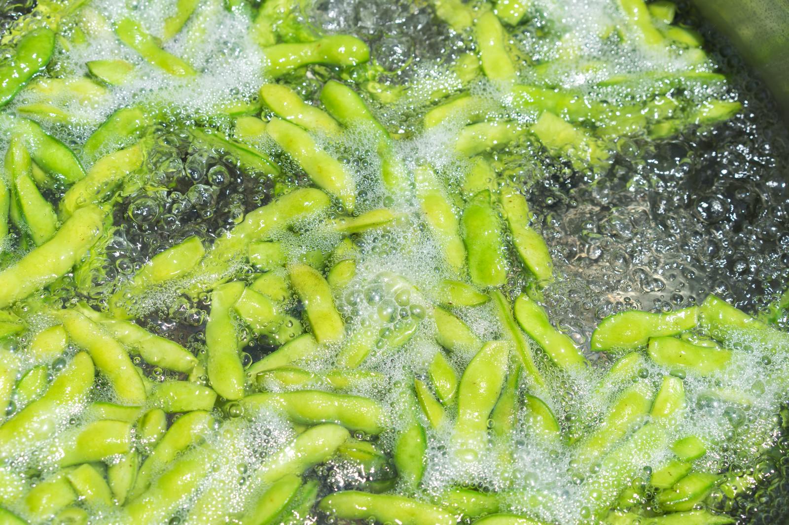 沸騰したお湯の中で茹でられている緑色の枝豆