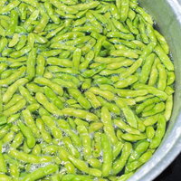 白い鍋で茹でた枝豆の湯気立つ調理風景の写真