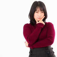 顎を人差し指と親指で挟む考える仕草をする女性の写真