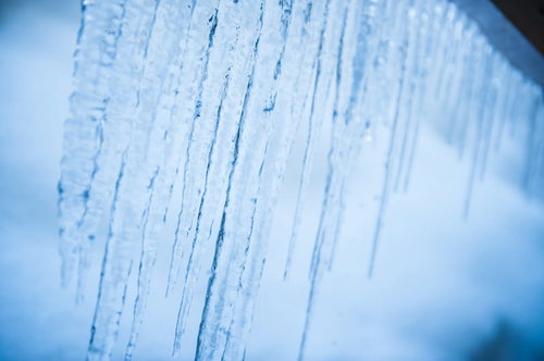 軒下に透き通るつらら、青みがかった氷柱が垂れ下がる冬の風情