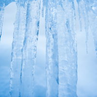積雪が透けて見える青い氷柱（つらら）の冬景色の写真