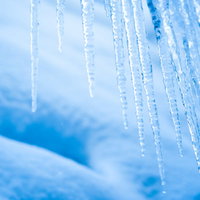 積雪と青く透明な氷柱が織りなす冬の自然風景の写真