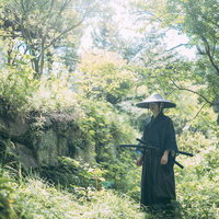 山中の小道に立つ侍（黒い着物・袴）の写真