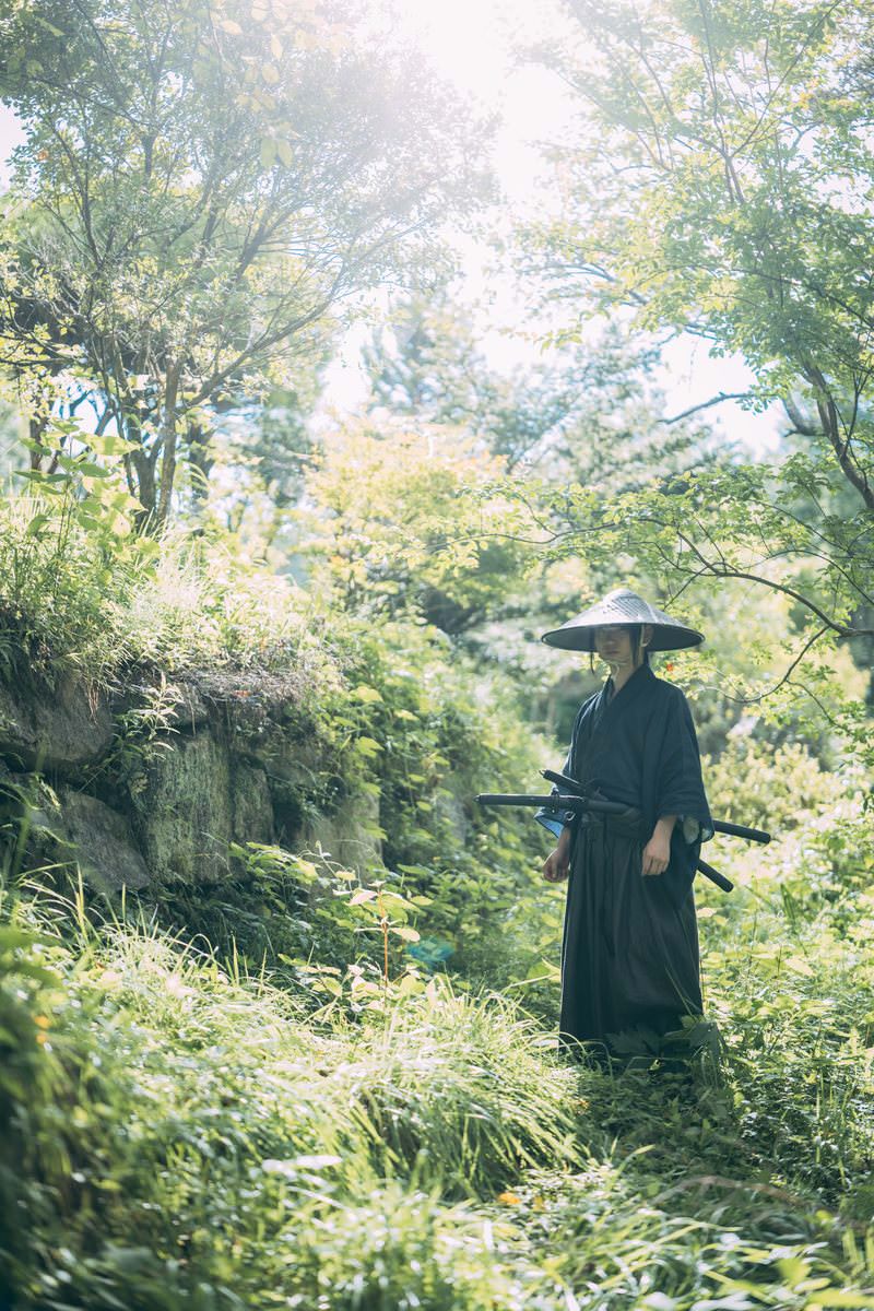 山中の小道に立つ黒い着物の侍［モデル：まーこ］