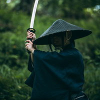 深い笠を被り刀を上段に構える用心棒の男性の写真