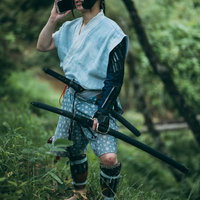 スマートフォンで通話中の野盗の和装姿の男性役者の写真