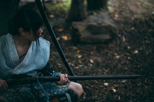 薄暗い森で火縄銃を握りしめる野盗一味の武装集団