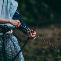 大弓を引く山賊の手元、弓矢を構えて狙いを定めるの写真