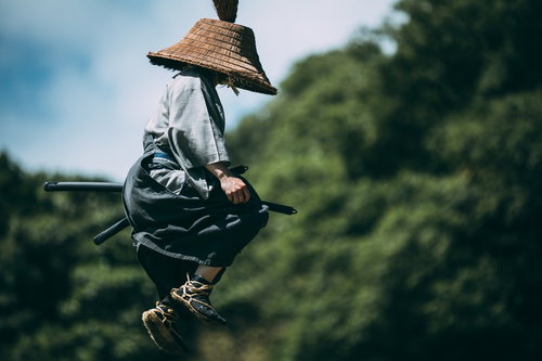 飛び上がる用心棒の麻混着姿と藁編み笠、アクション決めポーズ