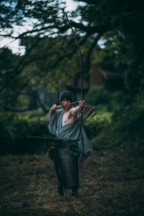 左肩を出して大弓をひく侍の姿勢と伝統的な弓術の風景