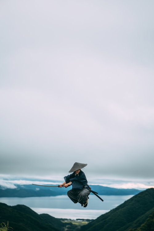 高く飛び上がり切りつける侍男性の時代劇アクション