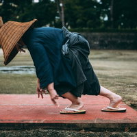 編み笠と袴姿でスタートダッシュする侍の徒競走の写真