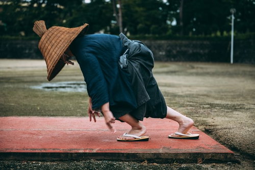 編み笠と袴姿でスタートダッシュする侍の徒競走