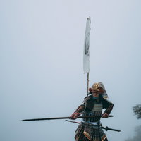 霧の中で刀を構える当世具足を纏う武士の戦闘姿の写真