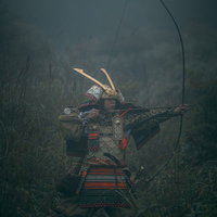 霧の中で大弓を引く鎧姿の侍・武士の弓兵・戦国時代の写真