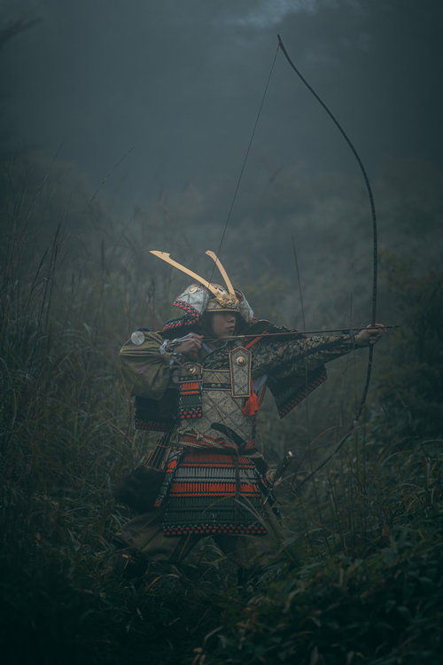 霧の中で大弓を引く鎧姿の侍・武士の弓兵・戦国時代