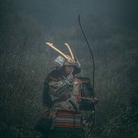 人差し指を舐める大鎧を纏う侍の弓武士の肖像の写真