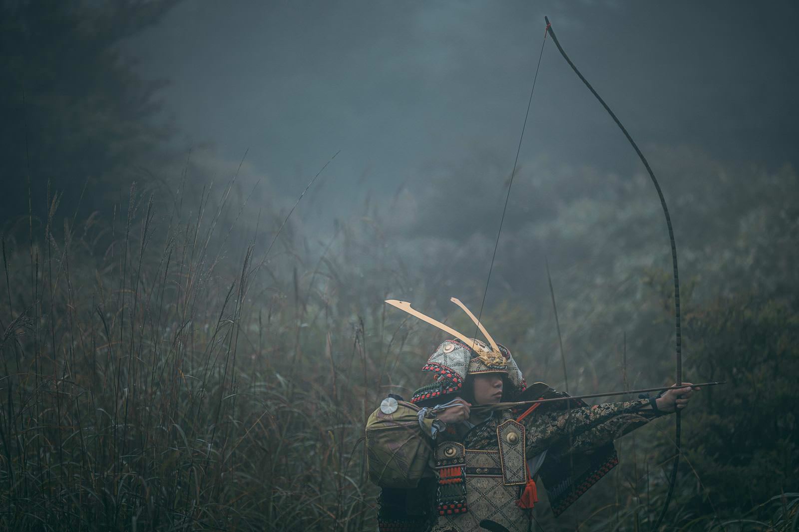 霧の中で大弓を構える大鎧姿の武将［モデル：まーこ］