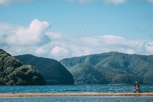 川の中州で斧を振りかぶる甲冑姿の侍の勇壮な姿