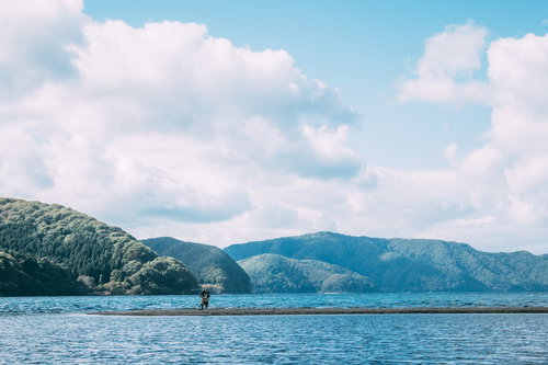 刀を振りかざす武士が水辺の中州に立つ戦国時代の武装姿