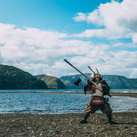 海辺で棍棒を大きく構える武将、大鎧姿の侍の写真