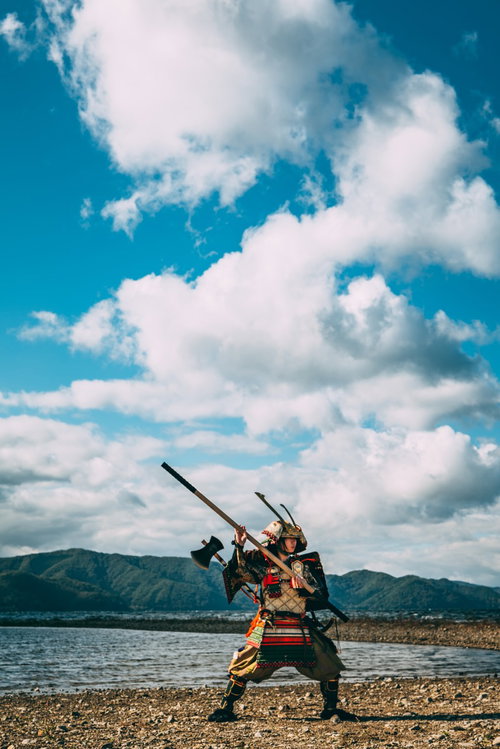 湖畔で大鎧を纏って棍棒を振りかぶる武装した戦国武将
