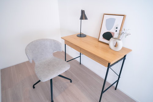 木目調の物書き台と白い椅子のシンプルなワークスペース