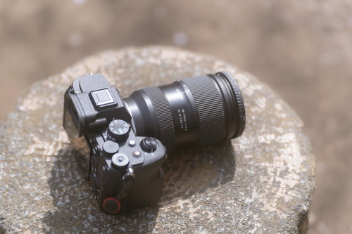 石の上に置かれたミラーレスカメラとレンズ機材